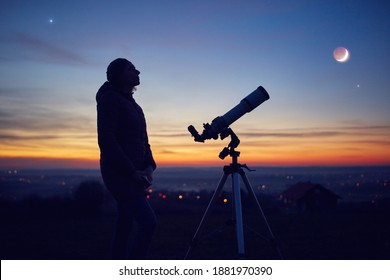 Woman looking at night sky with amateur astronomical telescope. - Shutterstock ID 1881970390