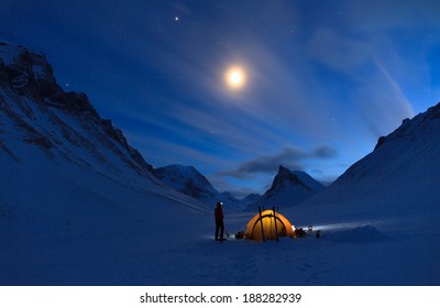 Woman looking at the night sky while camping in the snow covered mountains in Swedish Lapland (Nallo). - Powered by Shutterstock