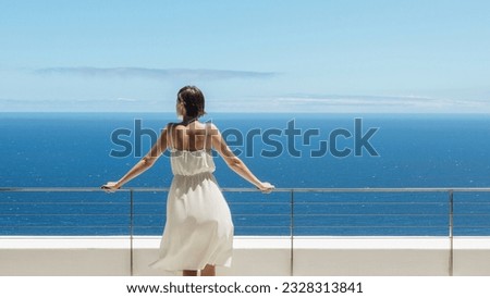 Woman looking at ocean from balcony