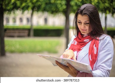 Woman looking on the map at the city park Paris, France
