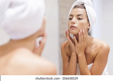 Woman looking on reflection in the mirror after shower  - Powered by Shutterstock