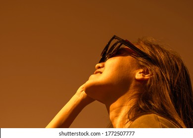 Woman Is Looking On Solar Eclipse Through Three Sunglasses. Sun Eclipse Concept.