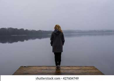 Woman looking onto a lake  - Powered by Shutterstock