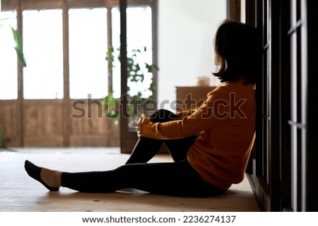 A woman looking out with a dark feeling
