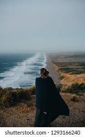 Woman looking out over a vast coastline. - Shutterstock ID 1293166240