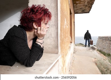 Woman Looking Out Of The Window At A Man Leaving Her House