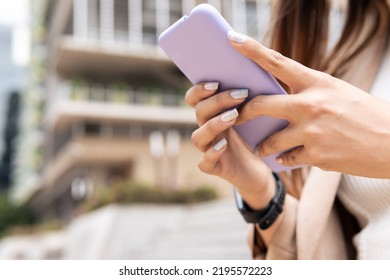 A Woman Is Looking At The Phone Outside