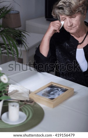Woman looking at the photo of her dead husband