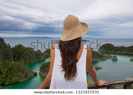 woman looking piaynemo island panorama from a balcony,west papua