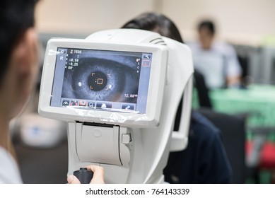 Woman Looking At Refractometer Eye Test Machine In Ophthalmology