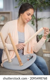 woman looking regretfully at broken stool