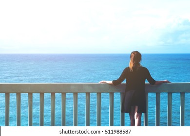 A woman looking to the sea in front of the beautiful ocean and sky view