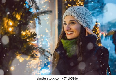Woman Looking In Shop Window On Christmas Shopping Gifts