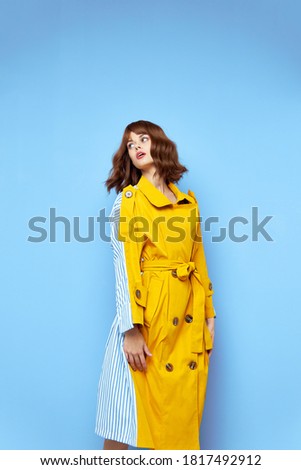 Woman looking to the side and yellow coat with buttons fashionable clothes