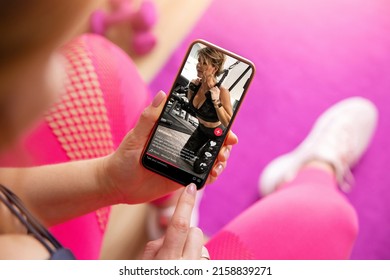Woman looking at someone's fitness videos shared on social media