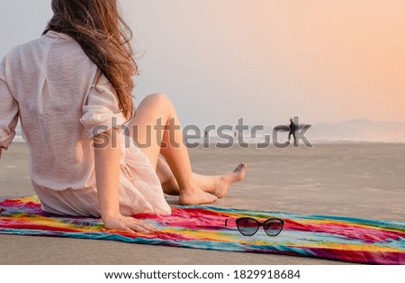Woman looking at surfer man on the beach
