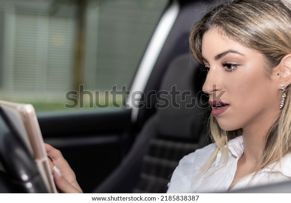 woman looking at a tablet in\
a car