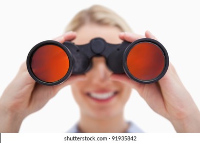 Woman looking through binoculars against a white background
