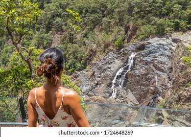 Woman looking at waterfall. Kuranda Scenic Railway Train. Tourist train journey across waterfalls, rainforest and jungles in Cairns Australia. View of beautfiul Stoney Creek Falls. Slow Motion.