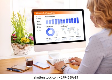 Woman looking at website traffic analytics data on computer