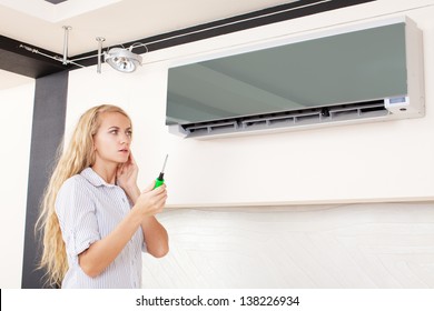 Woman Looks At A Broken Air Conditioner