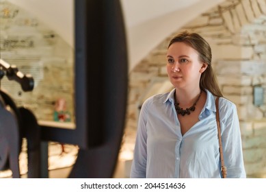 Woman Looks At Old Water Clock In Museum.