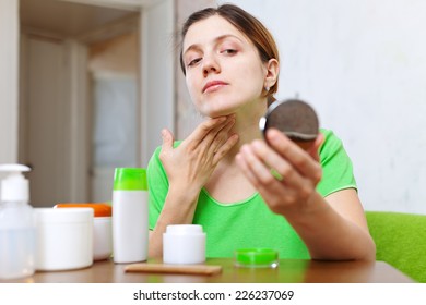 Woman Looks On Her Neck In Mirror  