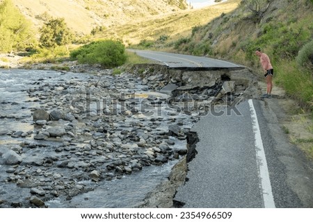 Woman Looks Over The Edge of The Washed Out Road In Yellowstone National Park