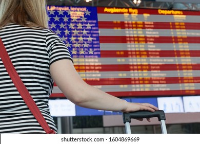 Woman looks at the scoreboard at the airport. Select a country USA for travel or migration.