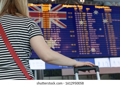 Woman Looks At The Scoreboard At The Airport. Select A Country Australia For Travel Or Migration.