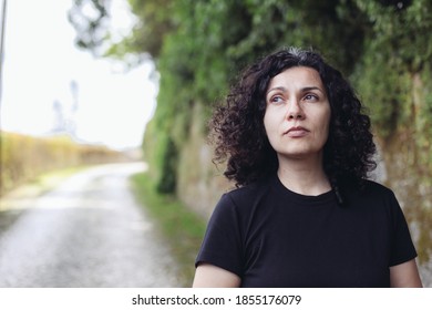A woman looks thoughtful, a road on the background
