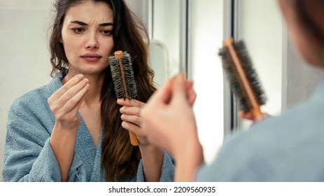 Woman losing hair on hairbrush in hand - Shutterstock ID 2209560935