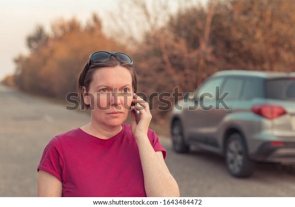 Woman lost\
during car driving through countryside talking on mobile phone\
trying to get help and roadside\
assistance