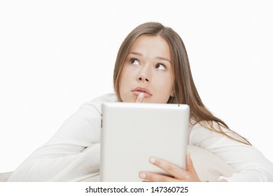 Woman lost in thoughts while using digital tablet