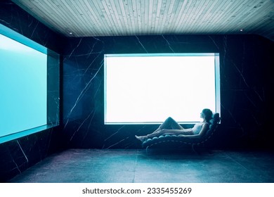 Woman in lounge chair in pool room - Powered by Shutterstock