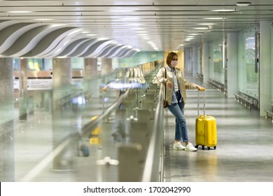 Woman With Luggage Stuck At Empty Airport Terminal Due To Coronavirus Pandemic/Covid-19 Outbreak Travel Restrictions. Flight Cancellation. Travel Industry Financial Crisis.Quarantine Isolation Measure