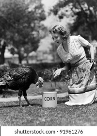 Woman Luring Turkey To Hatchet With Corn