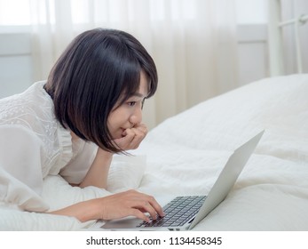 Woman lying in bed with laptop
