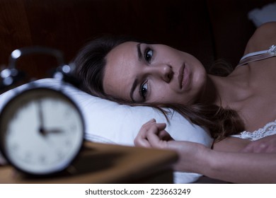 Woman lying in bed suffering from insomnia - Shutterstock ID 223663249