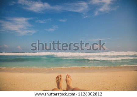 Woman lying down and enjoying on the tropical sandy beach. Summer concept.