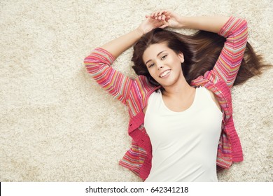 Woman Lying Down On Carpet, Happy Young Adult Girl Lie On Floor Top View