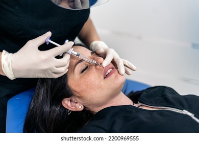 Woman Lying Down In Stretcher While Receiving Botulinum Toxin Injection In Beauty Clinic.