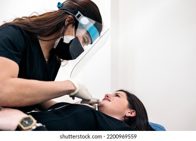 Woman Lying Down In Stretcher While Receiving Botulinum Toxin Injection In Beauty Clinic.