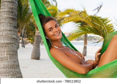 Woman Lying In Hammock On The Beach Is Listening Music Or Audiobook