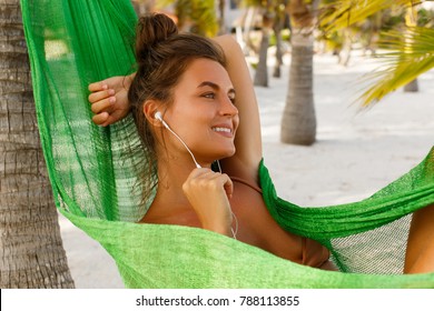 Woman Lying In Hammock On The Beach Is Listening Music Or Audiobook