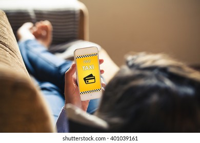 Woman Lying At Home Using A Mobile Phone To Pay A Taxi.