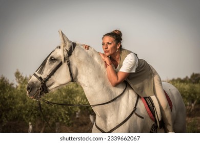 Woman lying on the back of a white horse - Powered by Shutterstock