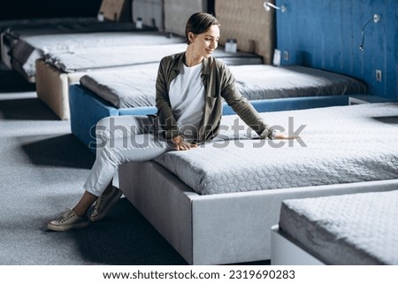 Woman lying on bed with orthopedic pillow in furniture store