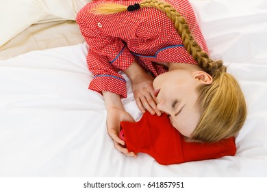 Woman Lying On Bed Sleeping With Warm Red Hot Water Bottle. Fever, Flu Treatment Objects Concept.