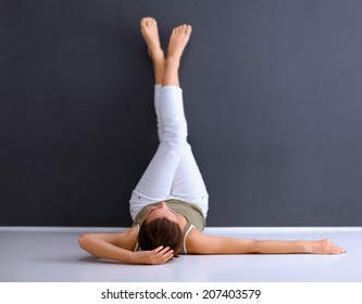 A Woman Lying On The Floor With Legs Up